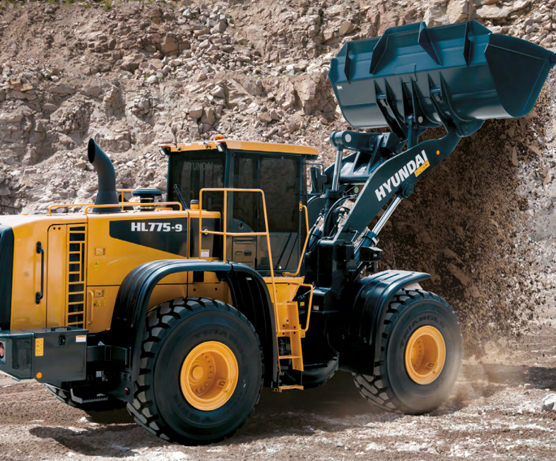 wheel loader in a sandy industrial site with large piles of material and conveyor belts in the background